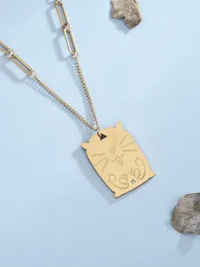 Dettaglio di un ciondolo a forma di gatto dorato con diamante su una catena a maglie miste