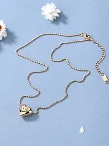 Detail van 18K gouden hart hanger ketting met roze kristal en ster edelsteen op kralenketting