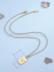 Dettaglio della collana in titanio dorato con ciondolo quadrato inciso e marchio K14