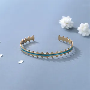 Adjustable golden bracelet with blue enamel inlay and geometric gear edge design