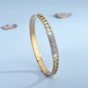 Bracelet à maillons cubains dorés avec plaque de zircone pavée sur fond bleu clair
