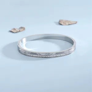 Bracciale ovale in acciaio argento con pavé di zirconi su sfondo blu minimalista