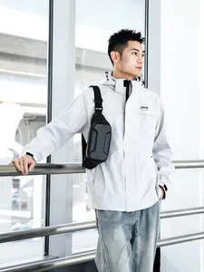 Close-up of black hardshell sling bag with carbon fiber texture on adjustable strap