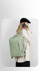 Close-up of light green travel backpack featuring built-in USB charging port and large capacity