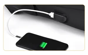 Détail du port de charge USB latéral sur un sac à dos noir avec un téléphone connecté