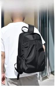 Vue latérale d'un homme portant un grand sac à dos noir étanche pour ordinateur