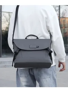 Detailansicht der grauen Kuriertasche mit Schnallen und Tragegriff für Herren im Freien