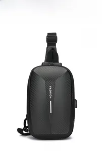 Détail du sac de poitrine rigide noir avec texture carbone et port de chargement USB externe