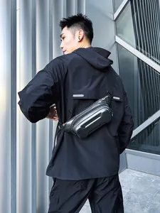 Outdoor shot of a black hard-shell carbon fiber chest bag for men with urban techwear style