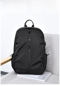 Détail du sac à dos business noir avec port USB et texture en nylon sur un canapé