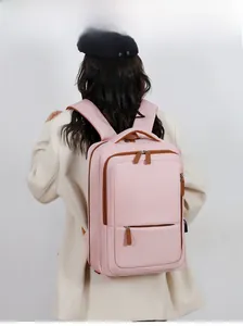 Pink travel backpack detail featuring USB charging port and multi-layer zipper texture