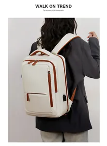 Detail of white business backpack featuring built-in USB charging port and brown accents