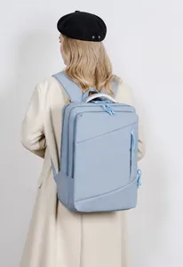 Rear view of a light blue geometric laptop backpack worn by a model on white background