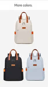 Detailed view of women's backpack in beige, black, and blue with leather handles