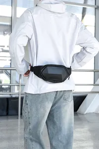 Close-up of black hard shell chest bag featuring carbon fiber texture and durable nylon strap