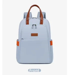 Front view of light blue-grey canvas backpack with brown leather handles and side pocket