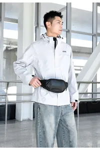 Outdoor male model wearing a black hardshell chest bag with geometric carbon fiber texture