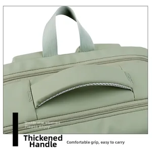 Detail of the thickened padded handle on a light green travel backpack for extra comfort