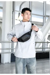 Close-up of black geometric hardshell chest bag with carbon fiber texture on model