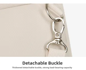 Close-up of durable metal swivel lobster clasp and D-ring on beige canvas backpack strap