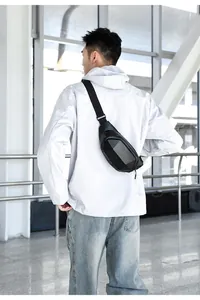 Black hard shell sling bag with carbon fiber texture worn by male model in modern interior