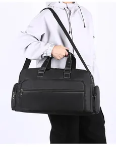 Detailansicht der großen schwarzen Reisetasche mit Reißverschlussfächern und Gurt