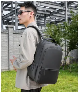 Side view of a large black waterproof business backpack worn by a model in outdoor setting
