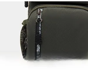 Detail of smooth metal zipper and olive green water-repellent fabric on tactical bag