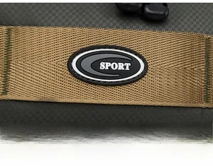 Close-up of khaki woven strap with SPORT rubber patch and green stitching on black bag