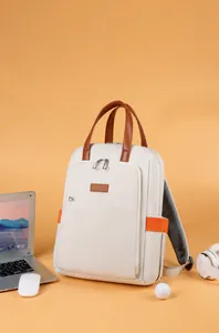 Detail of laptop backpack with brown leather handle and orange side ribbon accents