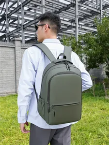 Outdoor shot of army green water-resistant laptop backpack worn by a male model
