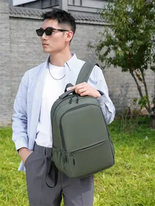 Close-up of waterproof dark green backpack with large front zipper pocket on lawn