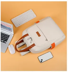Flat lay of a beige laptop backpack with orange straps and tech accessories