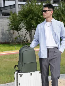 Waterproof dark green laptop backpack for business and travel shown in an outdoor park
