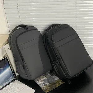 Detail view of the black waterproof business backpack on a desk with laptop and office tools