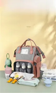 Detail of multi-functional diaper bag showing insulated bottle slots and side coin purse