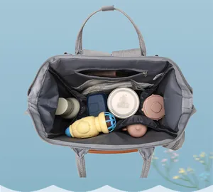 Macro view of gray diaper bag interior with wide opening and multiple storage pockets