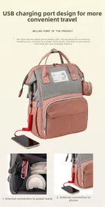Detail of pink and grey diaper bag showing external USB charging port and spacious interior