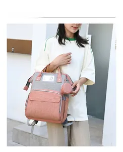 Detail of pink and grey canvas diaper bag with shoulder straps and detachable pouch