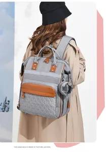 Detail of grey diaper backpack featuring heart quilting and premium leather carry handle