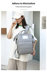 Detail view of multifunctional grey diaper backpack with front pocket and round coin purse
