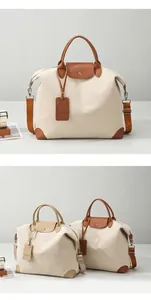 Detail view of large canvas travel bag with premium leather handles and brand hangtag