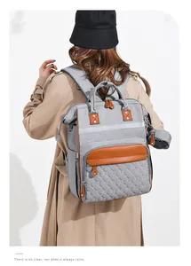 Detail of grey diaper backpack featuring heart quilted pattern and reflective safety strip