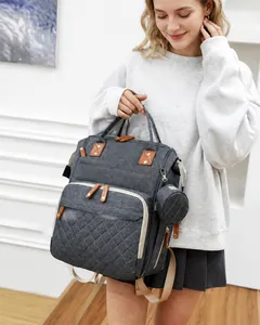 Fashionable grey quilted diaper backpack with leather trim and matching small pouch charm