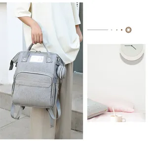 Close-up of gray large capacity diaper backpack with side pocket and small round accessory