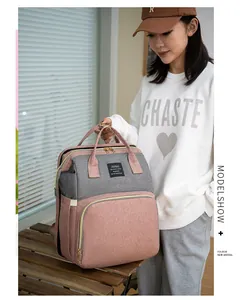 Vue de face du sac à dos à langer multifonction rose et gris avec grande ouverture