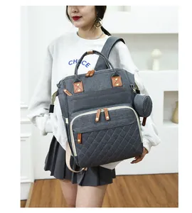 Detalle de mochila para pañales gris con bolsillo acolchado y monedero lateral pequeño