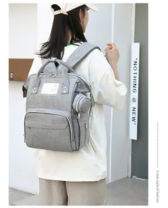 Grey multi-functional backpack with large capacity and matching round pouch worn by model