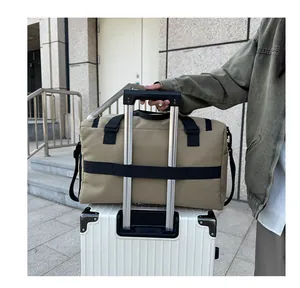 Dettaglio della borsa da viaggio kaki con fascia per trolley fissata alla valigia