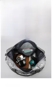 Interior view of silver quilted travel bag showing space for camera, books, and accessories